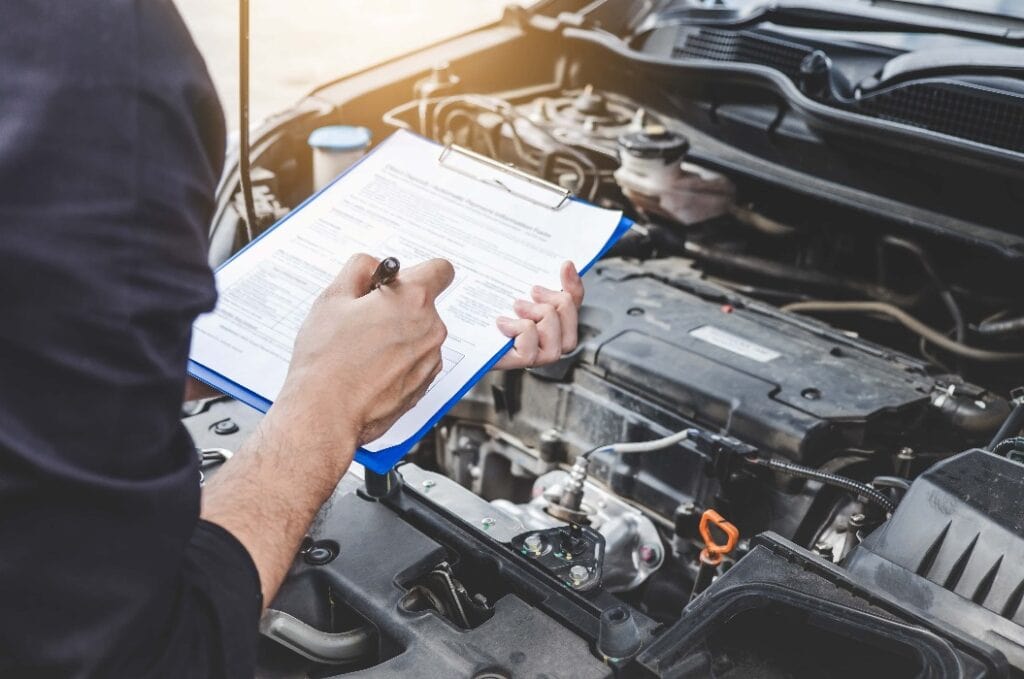 Services car engine machine concept, Automobile mechanic repairman checking a car engine with inspecting writing to the clipboard the checklist for repair machine, car service and maintenance